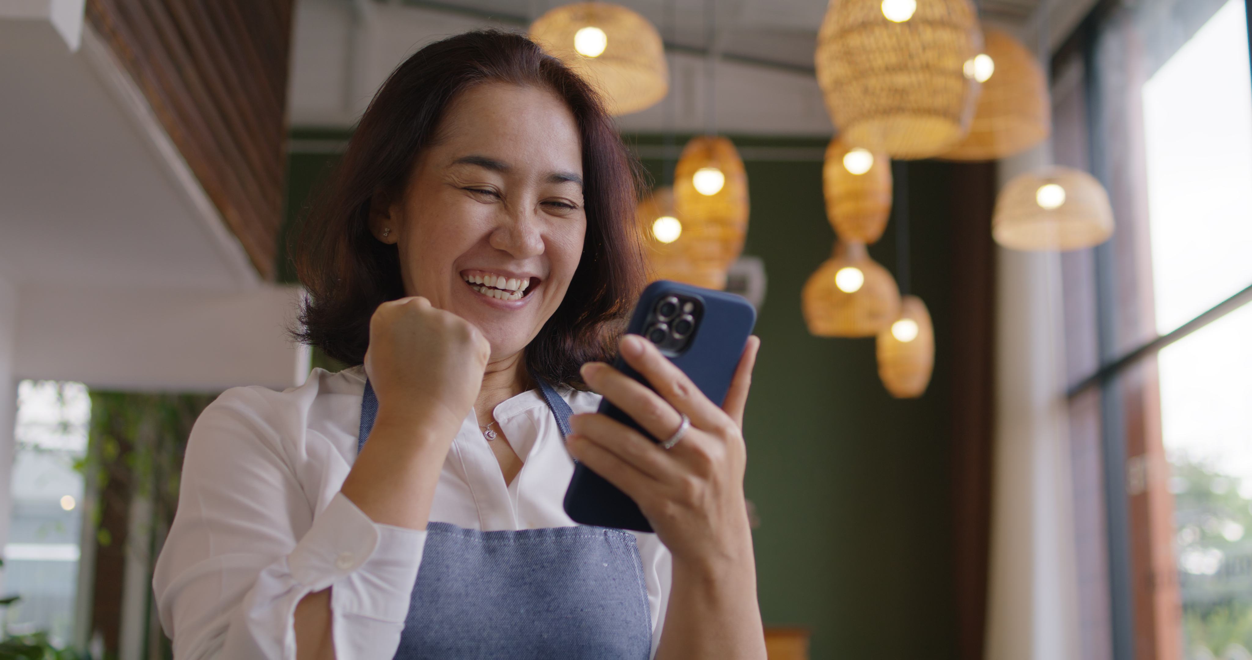 Restaurant operator reviewing customer demand on a phone